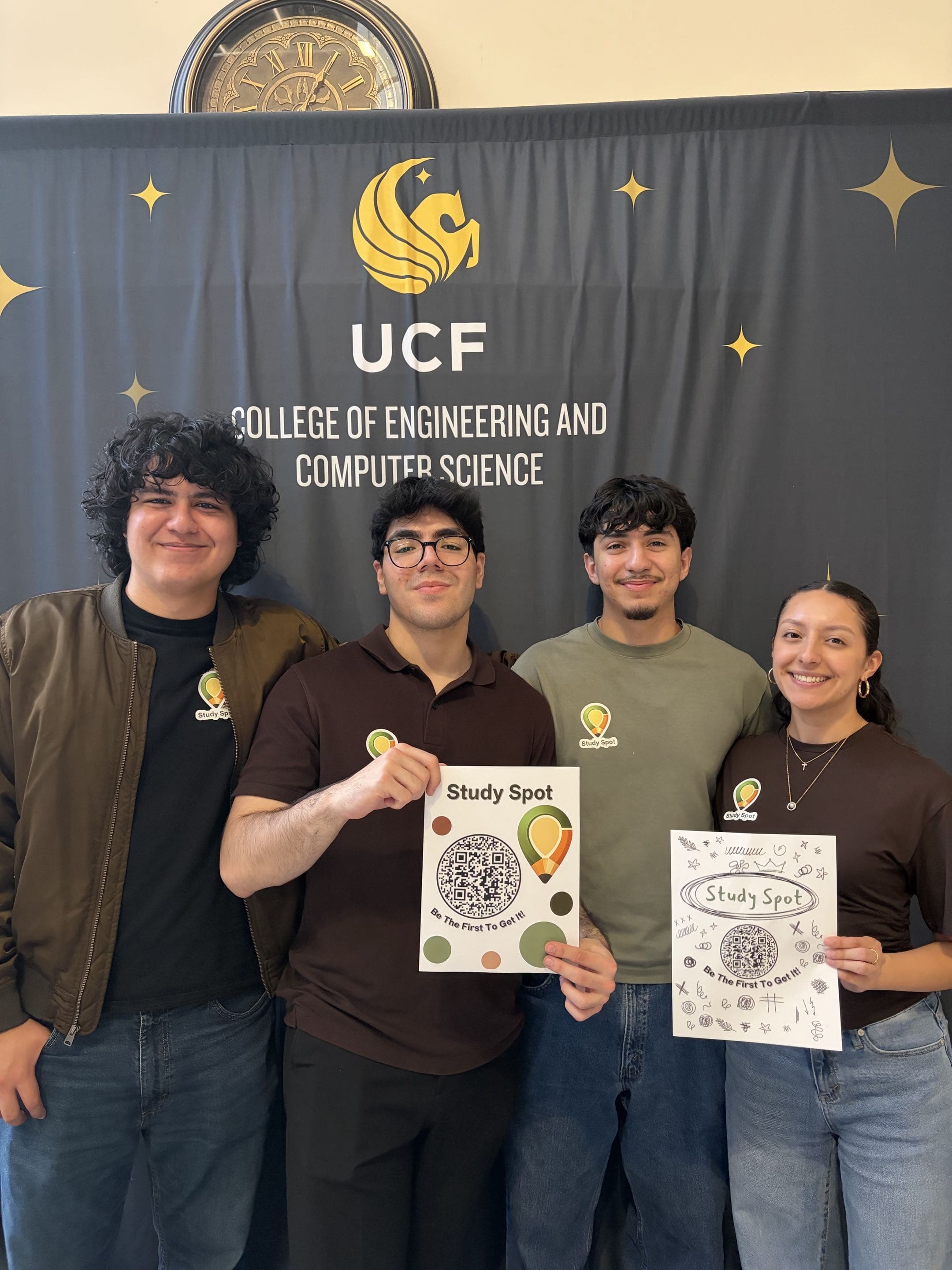 The four-person StudySpot team holding project posters in front of a UCF College of Engineering and Computer Science backdrop.